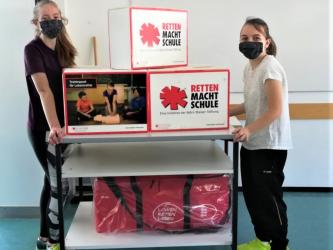 Eva E. und Éva H., die Leiterinnen des Schulsanitätsdienstes am HG, helfen beim Umziehen der EH-Trainingsmaterialien